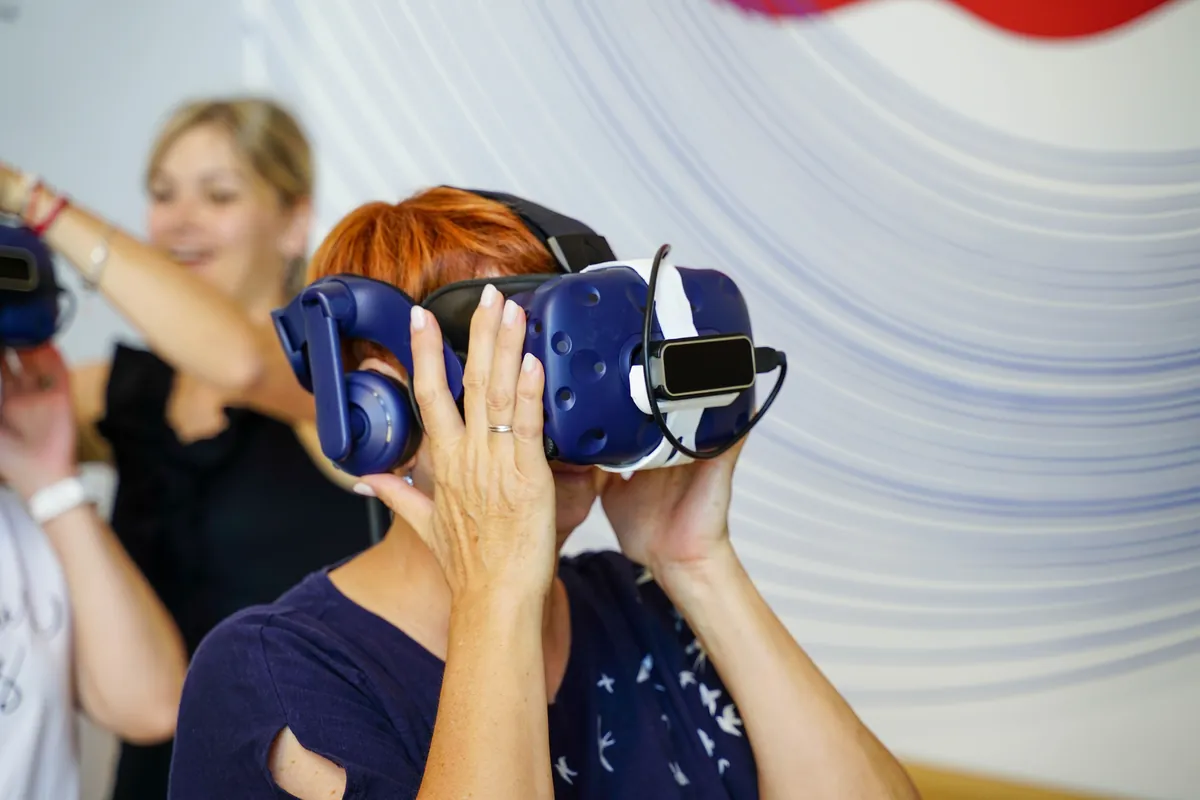 Des agriculteurs testent un casque de réalité virtuelle sur un stand lors d'un salon agricole professionnel