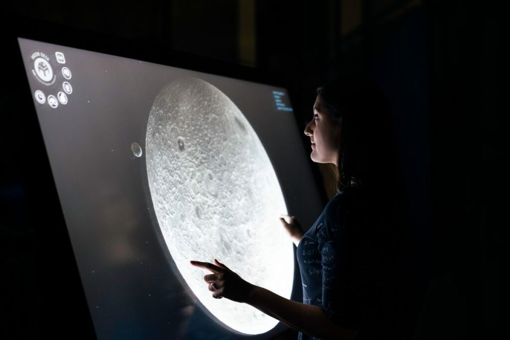 Personne interagissant avec un écran tactile - gamification de stand événementiel Uni-Wave