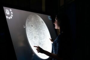 Personne interagissant avec un écran tactile - gamification de stand événementiel Uni-Wave
